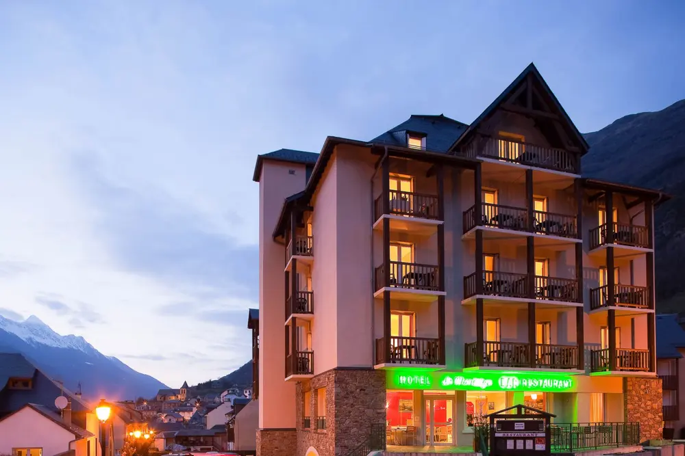 Hôtel Le Montaigu illuminé de nuit avec un éclairage chaleureux