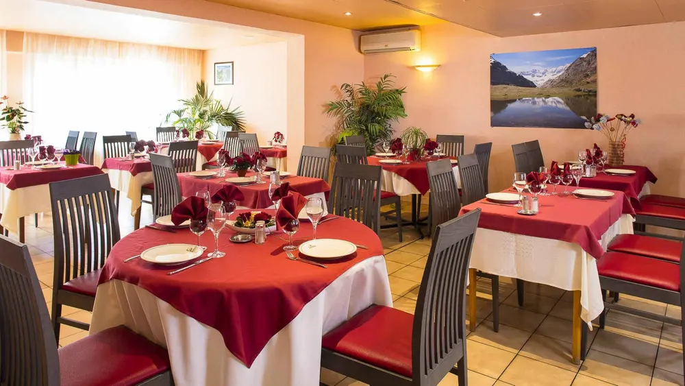 Salle de restaurant Le Montaigu, tables dressées pour le dîner